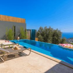 Villa Happy Vibes – Private pool honeymoon villa in Kalkan Akbel with stunning sea view, sun loungers, and modern holiday design.